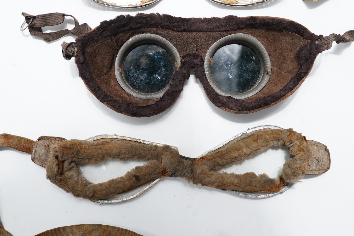 A pair of early aviation aluminium framed flying goggles, a pair of leather and felt lined goggles with green tinted lenses, a pair of French ? aviator flying goggles and a pair of WW2 First Pattern RAF Night Simulation